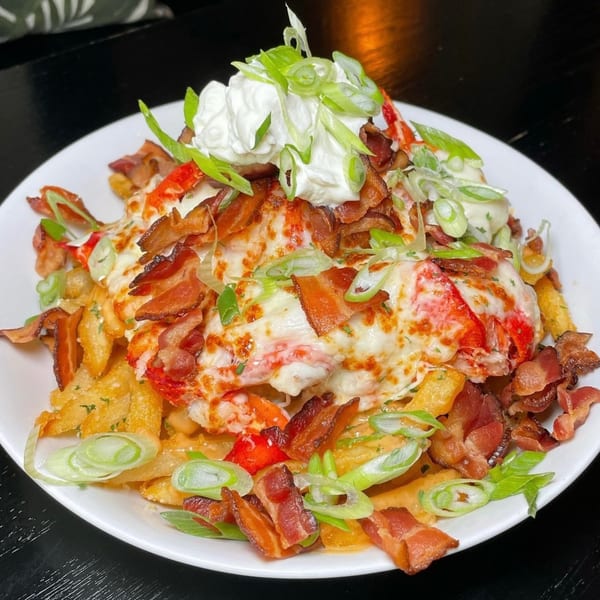 Salted. On The Harbor's lobster fries, topped with melted cheese, bacon, sour cream, and scallions.